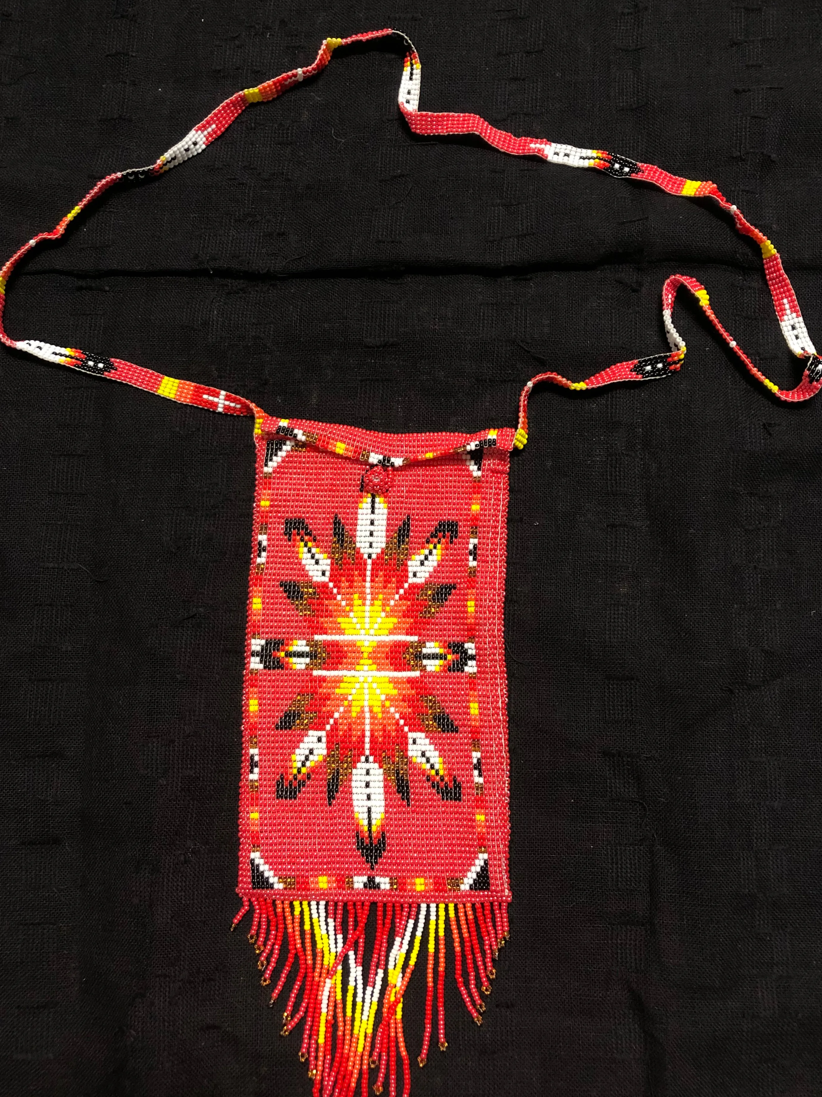 Guatemalan handcrafted glass bead shoulder bag, approximately 4” x 7” with a 32 inch strap.  The bags are decorated on both side