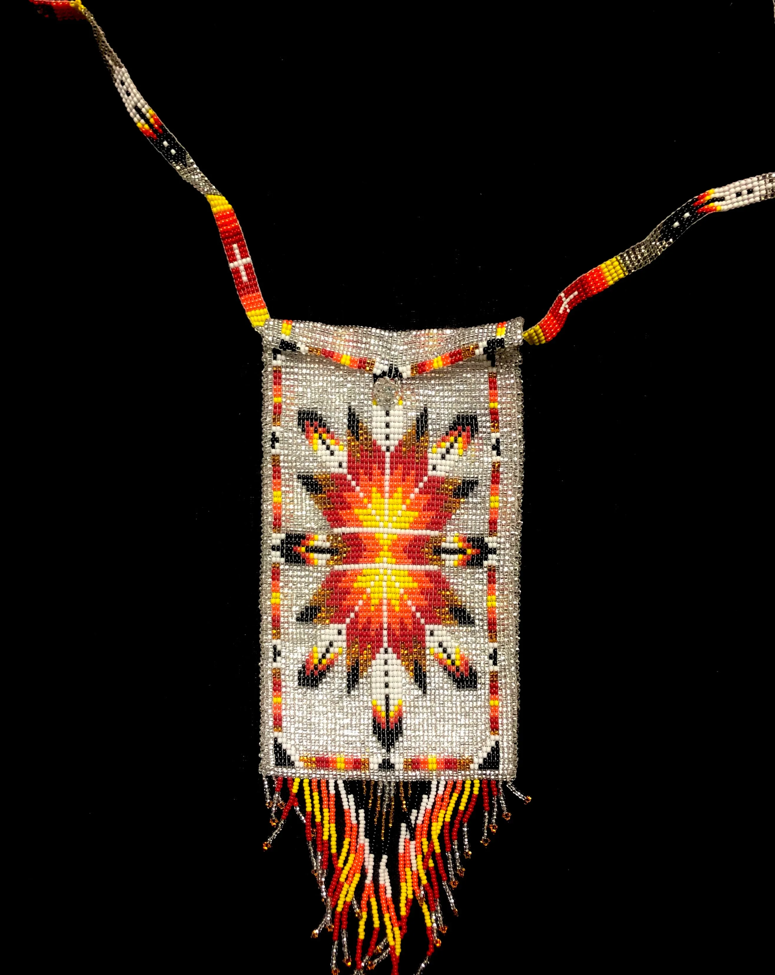 Guatemalan handcrafted glass bead shoulder bag, approximately 4” x 7” with a 32 inch strap.  The bags are decorated on both side