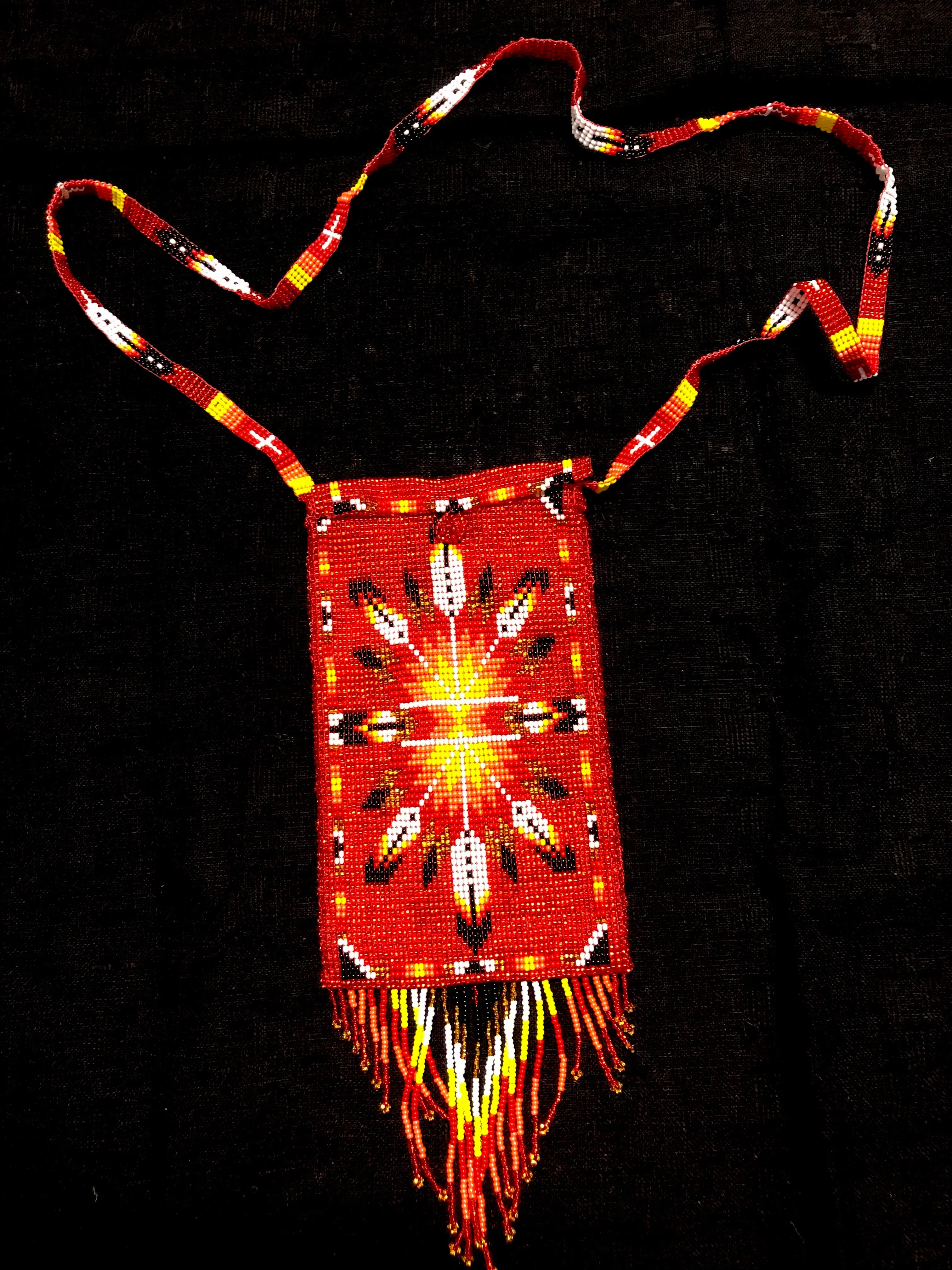 Guatemalan handcrafted glass bead shoulder bag, approximately 4” x 7” with a 32 inch strap.  The bags are decorated on both side