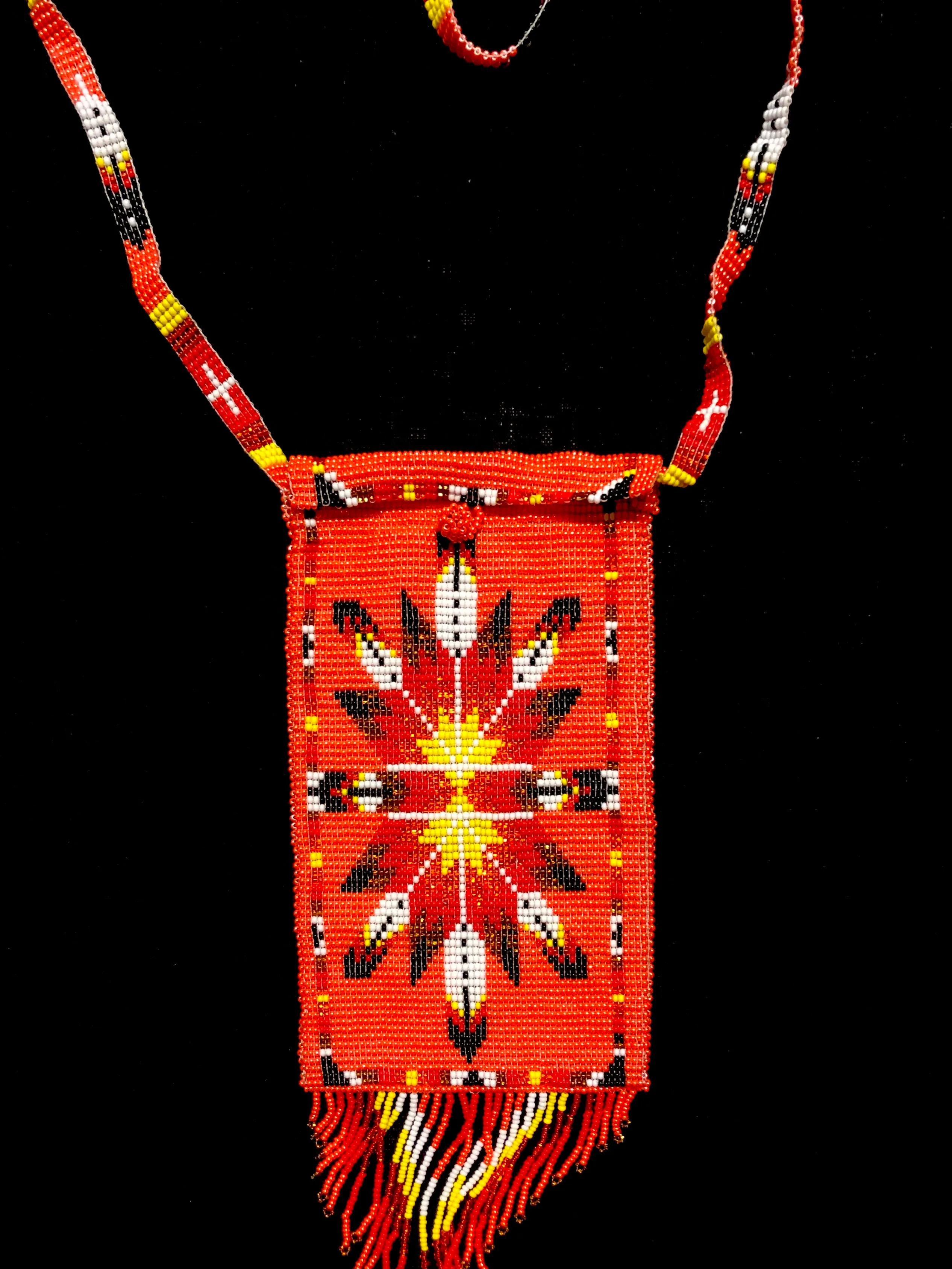 Guatemalan handcrafted glass bead shoulder bag, approximately 4” x 7” with a 32 inch strap.  The bags are decorated on both side